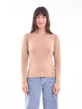 Remera de manga larga color tostado, con cuello redondo adornado con pequeñas tachas metálicas.