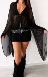 Vestido corto negro de estilo lencero con escote en V profundo, mangas largas acampanadas de tul transparente y diseño ajustado al cuerpo.