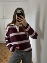 Sweater de tejido bremer doble a rayas horizontales en color bordó y rosado, con cuello polo en color blanco y escote en V.