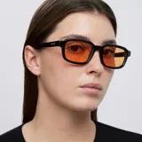 Lentes de sol con montura rectangular de color negro y cristales en tono naranja. Presentan un diseño contemporáneo con esquinas redondeadas y protección UV400.