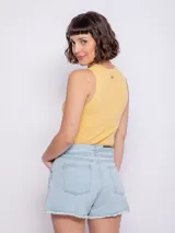 Short de jean celeste claro, tiro alto, con terminación desflecada en el ruedo y lazo de tela para atar en la cintura.