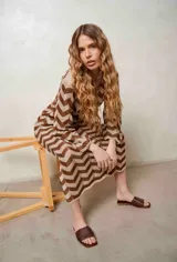 Vestido largo de lurex con diseño de patrón en zigzag en tonos tostado y marrón, escote en V con cordones para atar y mangas largas.