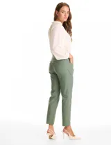 Pantalon de corte slim fit en color verde, confeccionado en tejido tecnico de alta densidad. Presenta una pretina ancha elastizada de estilo pull-on, sin cierres ni botones, y cuenta con cinco bolsillos funcionales.