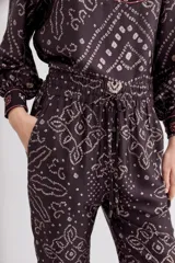 Pantalón tipo babucha de viscosa y modal con estampado estilo bandani. Presenta un corte fluido, cintura elastizada y cordón de ajuste con terminaciones metálicas.