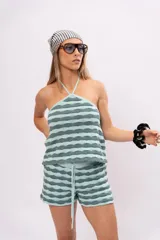 Top tejido a rayas horizontales en tonos verde agua y gris, con cuello halter y espalda descubierta.
