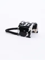 Colero con base cilíndrica de resina con estampado abstracto en blanco y negro, y elástico negro.