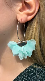 Caravanas tipo argolla plateada con aplique decorativo en forma de abanico compuesto por pétalos de tela en color turquesa.