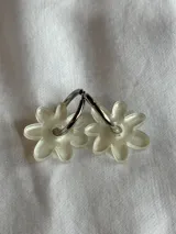 Aros de argolla metálica con dije colgante en forma de flor de acrílico color rosado.