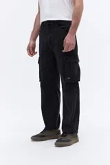 Pantalón tipo cargo confeccionado en denim de algodón con efecto lavado. Presenta un calce relajado de tiro medio, con bolsillos laterales tipo cargo y costuras reforzadas en las rodillas.