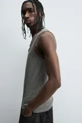 Camiseta sin mangas (tank top) negra, de corte slim fit, con cuello redondo de efecto doble.