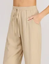 Pantalón holgado de lino color beige de la marca Allie Rose, con tiro alto y pretina elastizada con cordón de ajuste.