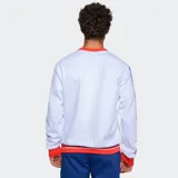 Buzo de cuello redondo color azul, con detalles en rojo y blanco en cuello, puños y ruedo. Presenta el escudo del Club Nacional de Football en el pecho y bandas laterales con diseño deportivo en las mangas.