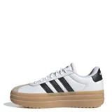 Championes Adidas modelo VL Court Bold, de diseño urbano con plataforma alta. Presentan una base de cuero blanco con las icónicas tres tiras laterales en negro, puntera de gamuza en tono gris claro y suela de goma color caramelo.