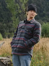 Camisa overshirt de micropolar con diseño a rayas horizontales multicolor. Cuenta con cuello clásico, cierre frontal de botones, dos bolsillos superiores con solapa y bolsillos laterales. El interior está forrado con tafeta acolchada para mayor abrigo.