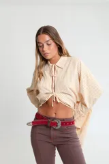 Cinto negro de cuero con hebilla plateada estilo western y apliques de tachas plateadas.