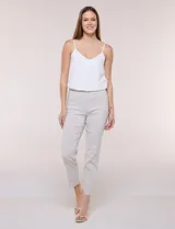 Pantalón de gabardina elastizada color beige, de tiro medio y calce slim. Cuenta con diseño pull-on sin cierres ni botones, cintura ancha, bolsillos delanteros simulados y bolsillos traseros ojal.