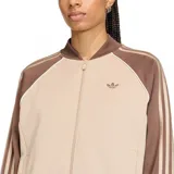 Campera deportiva Adidas SST Loose Tracktop, color beige con mangas y cuello marrón. Presenta las tres rayas características de Adidas en las mangas y el logo bordado en el pecho.