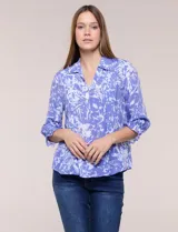 Blusa azul con estampado tipo pincelada en tonos blancos, cuello solapa con escote en V, media abotonadura frontal con botones nacarados, mangas tres cuartos con puños elásticos y diseño semi holgado.
