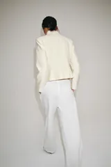Chaqueta estilo militar ZW Collection confeccionada en hilatura con mezcla de algodón, color crudo, con cuello subido, manga larga, falsos bolsillos de vivo y cierre frontal con ganchos metálicos y botones decorativos dorados.