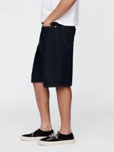 Short de jean de corte holgado y largo hasta la rodilla, en color azul oscuro con costuras en contraste.