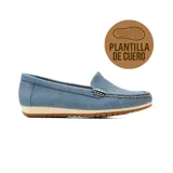 Zapato mocasín casual Korium modelo Cora, color celeste con textura tramada, detalle de aplique metálico en el empeine y suela de goma blanca con base marrón.