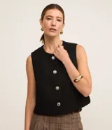 Chaleco negro de tweed con cuello redondo y abotonado delantero. Posee pences delanteros y tejido texturizado.