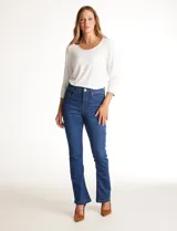 Jean de tiro alto con corte bootcut, ajustado en cadera y muslos con una sutil apertura desde la rodilla. Presenta diseño clásico de cinco bolsillos, cierre con botón y costuras en contraste. Su diseño posterior incluye costuras estratégicas para un efecto de realce en la silueta.