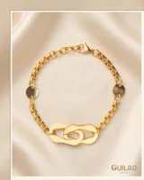 Pulsera de acero con baño de oro, compuesta por una cadena de eslabones finos y un dije central de eslabones ovalados entrelazados.