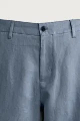 Bermuda relaxed fit confeccionada en lino color celeste, con bolsillos laterales, bolsillos traseros de vivo y cierre frontal con cremallera y botón.