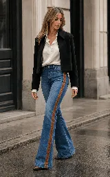 Jeans oxford de tiro alto color azul, con aplicaciones laterales de cuero color suela unidas mediante un delicado trabajo de lazado en cruz a lo largo de las piernas.