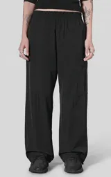 Pantalón cargo de corte oversize confeccionado en microfibra elastizada. Presenta cintura elástica, bolsillos laterales y un bolsillo cargo con cierre de broche a presión. Incluye un sistema de elásticos con tancas en los tobillos para regular la apertura.