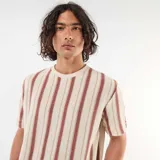 Remera de manga corta con diseño de rayas verticales en tonos beige y bordó, confeccionada en tejido de punto texturizado.