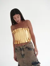Top strapless de cuero color dorado, con diseño de tablas frontales estructuradas y elástico en la espalda.