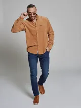 Camisa marrón de pana de manga larga con cuello abotonado y bolsillo en el pecho.