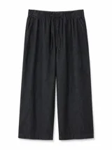 Pantalón tipo jean color negro, de corte ancho y holgado, con cintura elástica fruncida y cordón ajustable.