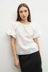 Blusa amarilla con estampado floral, mangas cortas abullonadas y cuello redondo.