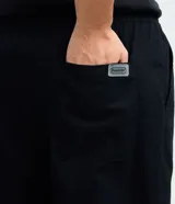 Pantalón de sarga corte relaxed, color negro, con cintura elástica y lazo de ajuste. Cuenta con bolsillos laterales y diseño liso.