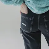 Pantalón negro de gabardina, corte recto y tiro alto, con costuras blancas a contraste.