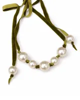 Collar tipo choker compuesto por una cinta de terciopelo verde oliva con perlas blancas de distintos tamaños intercaladas.