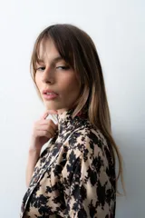 Blusa de seda con estampado floral en tonos marrón y celeste, con cuello alto, manga corta japonesa y cierre cruzado con botones negros visibles en diagonal.