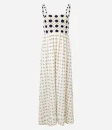 Vestido midi de algodón, color crema, con breteles finos. El corpiño presenta un diseño de crochet con motivos florales en azul marino, y la falda evasé tiene un estampado de pequeños íconos abstractos en azul.