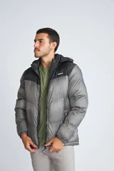 Campera puffer para hombre, color negro con canesú gris, capucha desmontable, cierre frontal con cremallera, bolsillos laterales con cierre y logo de la marca en el pecho.