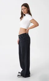Pantalón de jean estilo wide leg, de tiro bajo y corte holgado, en color negro lavado.