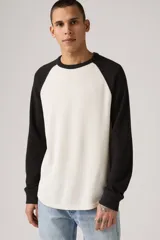 Remera térmica de manga larga con diseño raglán, color blanco en el cuerpo y negro en las mangas. Presenta un tejido texturizado tipo waffle y cuello redondo.