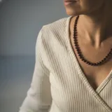 Collar de cuentas esféricas de piedra Ojo de Buey de 8 mm, con separadores de nudos de hilo color caramelo y detalles metálicos con baño de oro.