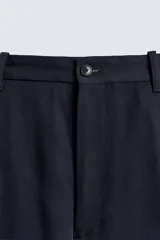 Pantalón de corte regular fit confeccionado en tejido ligero de lana de origen italiano. Presenta bolsillos frontales, bolsillos traseros de vivo con botón y cierre frontal con cremallera y botón.