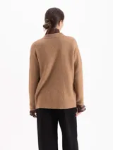 Cardigan de tejido de punto color marrón, con diseño de trenzas verticales, escote en V y cierre frontal con botones oscuros. Presenta mangas largas con puños acanalados y un corte holgado.