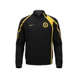 Campera deportiva Nike de cuello alto y cierre frontal completo. Presenta un diseño en color negro con detalles en amarillo en los laterales y hombros. Incluye el logo de Nike bordado en el pecho derecho y un emblema circular con el número 90 en el pecho izquierdo.