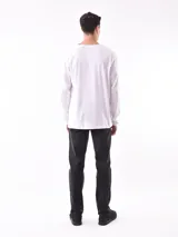 Remera blanca de manga larga, corte holgado y cuello redondo.