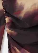 Vestido midi de manga larga acampanada, confeccionado en tejido de gasa con diseño tie-dye en tonos marrón y beige. Presenta cuello redondo, detalle fruncido en los hombros, fruncido lateral, diseño entallado y forro interior.